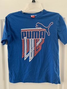 Puma ~short sleeve T-shirt ~ boys size M ~ blue With Logo. Super cool front logo design Puma cat logo on back Please excuse the wrinkles 😉 Shipped with USPS First Class. Front Logo Design, Kids Tshirt, Puma Cat, Cat Logo, Boys T Shirts, Super Cool, Wrinkles, Logo Design, Mens Graphic Tshirt