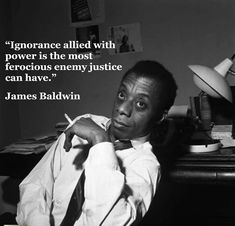 a man sitting in front of a desk with a quote from james baldwin on it