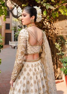 Golden White Lehenga Choli for Indian Bridal Wear a Heavily Embellished Bridal Choli Gown encrusted with Swarovski stones, Resham embroidery, and kora Dhaka along with a heavily embellished lehenga. Also, this is a handwoven silk lehenga with 16 organza panels. White Choli: A magical ethereal white outfit is precisely embellished with dazzling sequins, crystal, and pearls creating a divine embroidered composition with Mukesh. Korean silk choli is crafted in full-on hand embellishments with a mod Semi-stitched Hand Embellished Chinon Lehenga, Embellished Raw Silk Choli For Wedding, Wedding Choli In Embellished Raw Silk, White Hand Embellished Dupatta For Eid, White Hand-embellished Dupatta For Eid, Hand Embellished White Dupatta For Eid, Wedding Embellished Raw Silk Choli, Embellished Raw Silk Sets For Wedding, Festive White Hand Embellished Gown