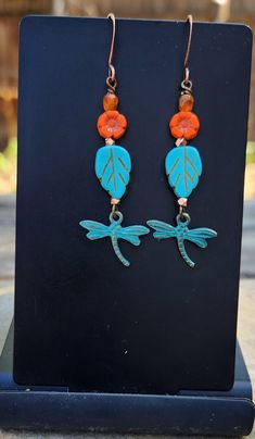 With these dragonfly earrings flying into your life, there is sure to be transformation and joy!  Dragonflies symbolize joy.  These are turquoise patina metal dragonflies that dangle at the end of a string of colorful Czech glass and copper beads.  Love the rich turquoise leaf and tiny orange flower! The dragonfly earrings measure just over 2 1/4 inches in length including the antique copper ear wire hooks.  Just the right earrings for a variety of outfits, from jeans and t-shirt to office attir Whimsical Turquoise Nickel-free Earrings, Adjustable Turquoise Flower Earrings Gift, Turquoise Flower Earrings Gift, Patina Metal, Jewelry Nature, Nature Earrings, Dragonfly Earrings, Earrings Turquoise, Leaf Jewelry