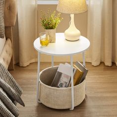 a white table with magazines and a lamp on it