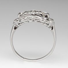 This beautiful vintage ring is centered with one (1) old European cut diamond set into a four-prong setting. The center stone is flanked to each side by one (1) round brilliant cut diamond set into a four-prong setting. The center stones are bordered with twelve (12), bead set, round single cut diamonds. The ring measures 9.7mm at the top, rises 5.1mm above the finger, tapering to 1.7mm wide and 1.1mm thick at the base of the shank. It is currently a size 8. Formal Diamond Ring With Rose Cut Round Stone, Formal Rose Cut Diamond Ring With Round Stone, Art Deco Three Stone Diamond Ring, Heirloom Three Stone Platinum Ring, Formal Rose Cut Diamond Ring, Heirloom Platinum Three Stone Ring, Heirloom Three-stone Platinum Ring, Heirloom Platinum Three-stone Ring, Vintage Single Cut Diamond Ring For Formal Occasions