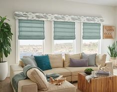 a living room filled with furniture and windows covered in blue roman blind shades on top of them