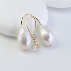 These earrings start with a matched pair of stunning genuine freshwater pearls. They each dangle on minimalist, custom 14K settings that I make by hand. My favorite thing about these earrings is how the large pearls look even more creamy smooth and luminous next to the bright, reflective gold. It's a lovely marriage and a perfect balance - minimal and super luxurious and feminine - they embody quiet luxury. The pearls are 15-16mm genuine, natural freshwater pearls. Made from solid 14K yellow gol Teardrop 14k Gold-filled Pearl Earrings For Anniversary, Teardrop 14k Gold Filled Pearl Earrings For Anniversary, 14k Gold Filled Teardrop Pearl Earrings For Anniversary, Elegant 14k Gold Filled Teardrop Earrings, Minimalist Yellow Gold Teardrop Pearl Earrings, Classic Pearl Drop Earrings In 14k Gold Filled, Minimalist Drop Pearl Earrings For Anniversary, Formal Teardrop Pearl Earrings In 14k Gold, White Pearl Earrings In 14k Gold For Wedding