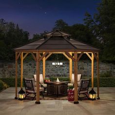 a gazebo sitting on top of a stone patio next to a table and chairs