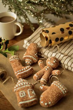 some gingerbreads are sitting on a table next to a cup of coffee and a christmas tree