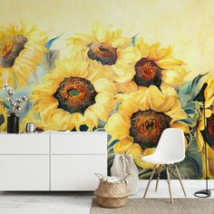 sunflowers are painted on the wall next to a white cabinet and sideboard