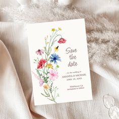 save the date card with watercolor flowers and feathers on white fabric, closeup