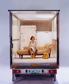 a woman sitting in the back of a moving truck