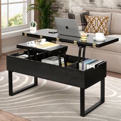 a laptop computer sitting on top of a wooden table in front of a couch next to a window