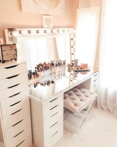 a white vanity with lots of drawers and makeup on it in a room next to a window