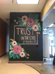 a chalkboard with flowers on it that says trust in the lord