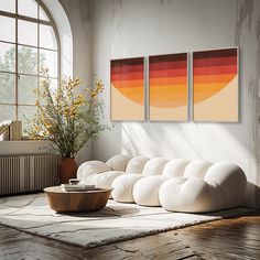 a living room with three paintings on the wall