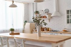 a vase with some flowers in it sitting on a kitchen table next to a window