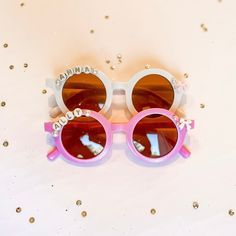 two pink and white sunglasses sitting on top of each other