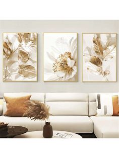 three paintings on the wall above a couch in a living room with white furniture and pillows