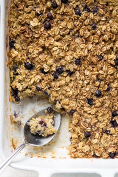 blueberry baked oatmeal in a white baking dish with a serving spoon