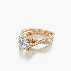 a yellow gold ring with a diamond in the center and two rows of diamonds on each band