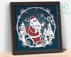 a paper cut christmas scene with santa in the center and snowflakes on the bottom