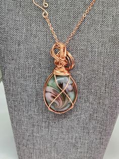 Discover the elegance of our handmade imitation opal pendant, meticulously wrapped in copper wire. This one-of-a-kind jewelry piece exudes artistic charm and sophistication, perfect for any special occasion. The pendant's intricate design showcases a stunning imitation opal encased in artistically twisted copper, creating a captivating focal point. An ideal gift for women who appreciate unique, handcrafted jewelry, this necklace adds a touch of elegance to any outfit, making it a must-have in your collection. I am on social media: Facebook, Instagram, Pinterest, TikTok, an Etsy. Copper Wire Necklace With Oval Pendant For Gift, Copper Wire Necklace With Oval Pendant As Gift, Wire Wrapped Copper Wire Teardrop Pendant Necklace, Oval Pendant Necklace In Copper Wire As A Gift, Copper Wire Teardrop Pendant Jewelry For Gift, Copper Wire Teardrop Pendant Jewelry Gift, Handmade Teardrop Pendant Necklace In Copper Wire, Rose Gold Copper Wire Necklace For Gift, Rose Gold Copper Wire Necklace Gift