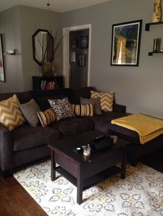 a living room with couches, tables and pictures on the wall in it's corner