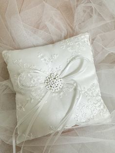 a white ring pillow with a bow on it