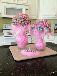 two vases filled with flowers on top of a kitchen counter next to an oven