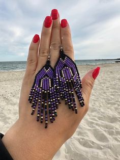 Adorn your fall outfit with these statement beaded earrings with fringe. Inspired by tribal style, these artisan seed bead earrings will sparkle with every move. These waterfall earrings have bright abstract design in black, purple and gold. It is a great finding for those who's looking for Halloween earrings as well as bohemian jewelry for autumn season. 100% top quality handmade earrings.  Length: 3.54''/ 9 cm Width: 1.18'' / 3 cm Materials:  - Czech seed beads - stainless steel accessories. The real color of the item may be slightly different from the picture shown on website caused by the brightness of your monitor. If you have special size requirements, please send me a letter about it, as this can be made to order. More beadwork earrings: https://etsy.me/30peGhg Back to shop: https:/ Purple Seed Bead Earrings, Purple Beaded Fringe Earrings For Gift, Purple Beaded Fringe Earrings For Festivals, Purple Bohemian Beaded Dangling Earrings, Purple Fringe Earrings, Unique Purple Beaded Earrings, Purple Beaded Earrings, Bead Things, Waterfall Earrings