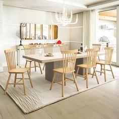 a dining room table with six chairs and a chandelier hanging from the ceiling