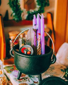 some candles are sitting in a pot on a table next to other items and decorations