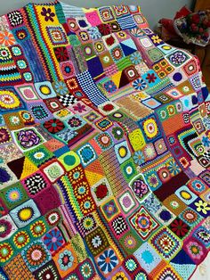 a colorful crocheted blanket is displayed on a table