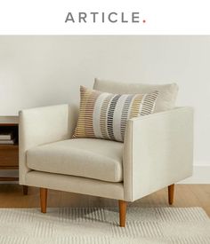 a chair with pillows on it in front of a white wall