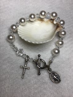 Pearl and crystal Rosary Bracelet, 6 3/4" long, with oxidized Miraculous medal and crucifix and has a toggle closure. Easy for putting on! Pearl is the birthstone for June! Perfect  for that special Birthday, gift for a bride or bridesmaids , First Communion girl, a special Mothers Day gift,  Easter! I you need a different size please let me know. Rosary Bracelet Catholic, Rosary Ideas, Heavenly Art, Crystal Rosary, Catholic Bracelet, Chaplet Rosary, Pearl Rosary, Rosary Bracelet, Girl A