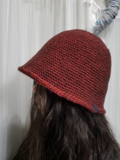 a close up of a person wearing a red knitted hat with horns on it