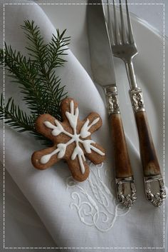 a fork and knife sitting on top of a white plate with snowflake decorations