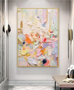 an abstract painting hangs on the wall above a bench