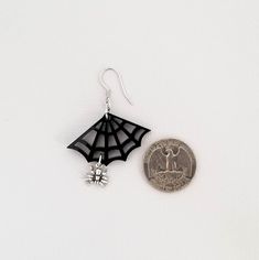 "These cute spiderweb earrings are the perfect gift for any girl who loves spiders. 💀 DESCRIPTION: This pair of drop earrings features small 3-D cast spider charms that hang from gloss black spiderwebs. They were attached to hypoallergenic stainless steel ear wires. 💀 SIZE & MATERIALS: The spiderwebs were laser cut from acrylic. The spider charms were made from sterling silver and measure approximately 3/8\". The ear wires are made from hypoallergenic stainless steel. Overall, the earrings Spooky Black Jewelry Gift, Themed Black Jewelry As Gift, Themed Black Jewelry Gift, Black Novelty Jewelry For Gifts, Nickel-free Black Spooky Earrings, Spooky Black Nickel-free Jewelry, Nickel Free Themed Black Jewelry, Black Novelty Drop Earrings, Themed Black Dangle Earrings