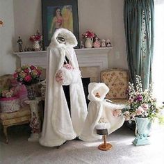 a woman in white fur coat standing next to a mannequin with flowers on it