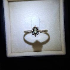 an engagement ring in a white box with a shadow on it's side,