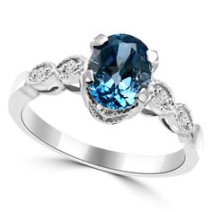 an oval blue topazte and diamond ring with white diamonds on the sides, set in