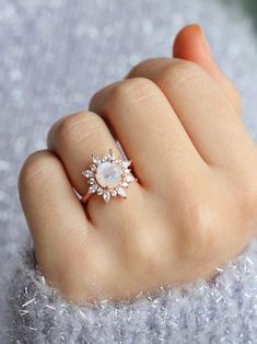 a woman's hand with a ring on top of it and a diamond in the middle