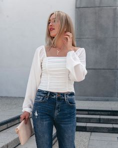 This White Pleated Top is an elevated must-have for the fall! Expertly crafted with 95% polyester and 5% spandex, the Zoe Pleated Detail Smock Top in white boasts a square neckline, long sleeves with elastic cuffs, and a smocked back for a flattering fit. With its pleated detail and side zip closure, this top is both stylish and comfortable! Style with jeans, ankle booties, and a matching little clutch for an elevated fall look. Sorority Rush Outfits, Rush Outfits, Gameday Dress, Loungewear Dresses, Casual White Dress, Pleated Top, Smock Top, Comfortable Style, Game Dresses