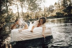 two women in white dresses are floating on an inner tube