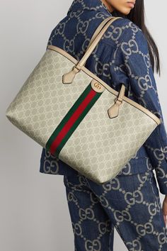 Gucci’s 'Love Parade' collection is filled with archival details and it doesn’t get more classic than the brand’s GG Supreme coated-canvas, which this 'Ophidia' bag is made from. Trimmed with leather, the pattern is broken up by the house’s web stripe and a hardware logo at the center. It’s carried by two handles and has a spacious interior with a zipped pocket for the smaller essentials. Gucci Outlet Handbags, Gucci Tote Bag Outfit, Gucci Ophidia Tote, Gucci Bags Outlet, Gucci Bags Handbags, Gucci Ophidia Bag, Luxurious Bags, Hardware Logo, Gucci Tote Bag