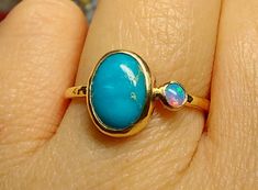 Please see the available Turquoises for your future ring (on photo number 3 of the listing's photos) and pick your favorite. This listing is another version of this same lovely ring : with tiny Opal/Pearl next to the Turquoise, but here it's WITH A THICKER (1.5 mm) band.  Both stones are set in 14k solid yellow gold,  with a 14k solid gold hammered band (1.5 mm wide)  underneath. Wonderful combination with a sense of old days... Shiny finish. - 1.5 mm hammered solid 14k yellow, or rose gold band Turquoise Oval Multi-stone Opal Ring, Turquoise Round Opal Ring In 14k Gold, Turquoise Opal Ring In 14k Gold, Turquoise 14k Gold Round Opal Ring, Birthstone Promise Rings, Rough Stone Ring, Turquoise Ring Engagement, December Birthstone Jewelry, December Birthstone Ring