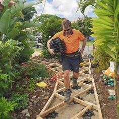 a man in an orange shirt is walking on a wooden walkway with shoes and equipment