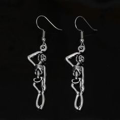 pair of alloy material earrings. measuring 2.5 inches in length Gothic Single Stainless Steel Earring, Trendy Silver Halloween Earrings, Edgy Pierced Metal Earrings, Edgy Metal Earrings With Ear Wire, Trendy Dangle Earrings For Halloween, Edgy Silver Drop Earrings, Trendy Pierced Earrings For Halloween, Trendy Halloween Dangle Earrings, Gothic Stainless Steel Jewelry