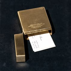 a close up of a metal object on a black surface with a card in it