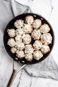 a skillet filled with powdered sugar covered muffins