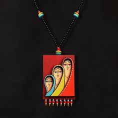 a necklace with three women on it and beads hanging from the end of each bead